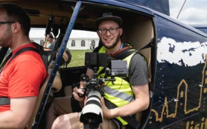 Unser Kameramann Roman Gubser in einem Helikopter, um das Flugfest auf dem Flugplatz Speck-Fehraltorf aus der Luft filmen zu können.